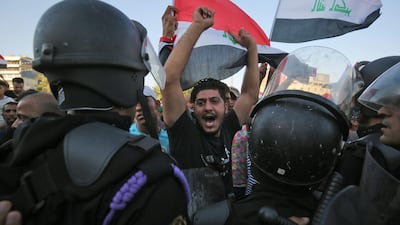 Iraqi protesters shout slogans and wave national flags during clashes at a demonstration against unemployment and a lack of basic services in the capital Baghdad's Tahrir Square. AFP