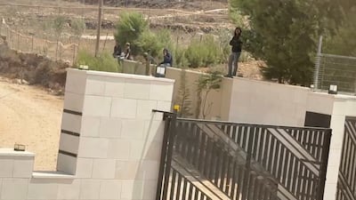Israeli settlers outside the front gate of a besieged Palestinian home in Qusra. Reuters