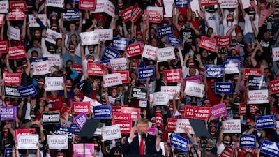 Attendees cheer and hold up signs as US President Donald Trump speaks at a campaign rally in Macon, Georgia. AFP