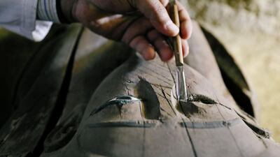 Egyptian antiquities worker brushes a coffin inside the recently discovered burial site in Minya, Egypt. Mohamed Abd El Ghany / Reuters