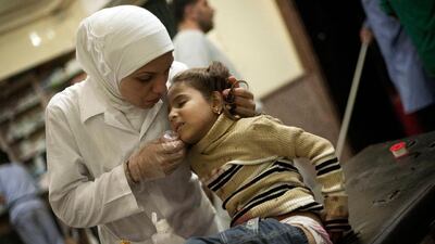 The caring hands of a Syrian nurse at Dar Al Shifa hospital treats a girl wounded by Syrian Army artillery shelling.