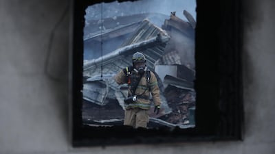 A firefighter tries to put out a fire of houses destroyed by a forest fire in Sokcho. Yonhap / AFP