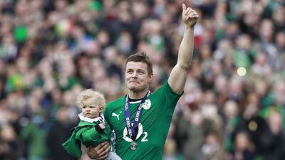 Ireland’s Brian O’Driscoll waves to spectators as he carries his daughter Sadie at the end of the Six Nations game against Italy at Aviva Stadium in Dublin, with Ireland convincing winners. Cathal McNaughton / Reuters