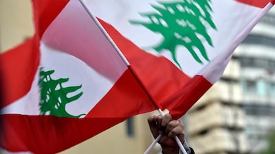 A protester waves Lebanese national flags as he takes part in a demonstration against the nomination of Hassan Diab as Prime Minister, outside his house in Beirut. EPA