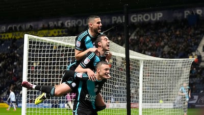 Harry Winks and Conor Coady jump on Jamie Vardy in celebration after Vardy scored Leicester's second goal. PA