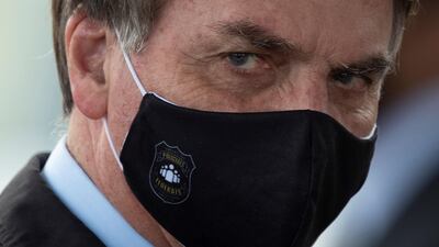 The president of Brazil, Jair Bolsonaro, leaves the Palacio da Alvorada to see dozens of his supporters, in Brasilia. Brazil has the second most confirmed cases of Covid-19 worldwide. EPA
