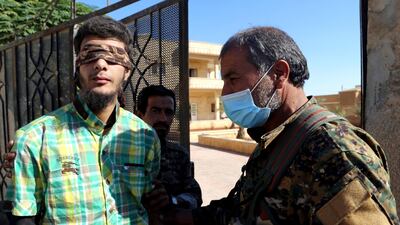 Members of the Syrian Democratic Forces (SDF) escort a blindfolded civilian detainee suspected to be a member of ISIL in Raqqa, Syria on October 12, 2017. Issam Abdallah / Reuters