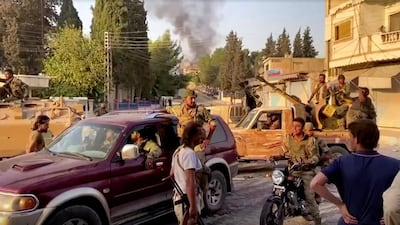 Armed rebel soldiers are seen on the street of Tal Abyad, Syria, in this screen grab taken from video. Reuters