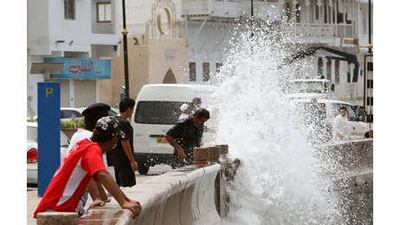 Omanis watch the waves hitting against the seawall along the Muscat Corniche yesterday, as they brace for a possible strike from Cyclone Phet.