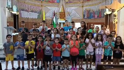 A screenshot from a video posted on Facebook showing children praying at the Holy Family Church in Gaza