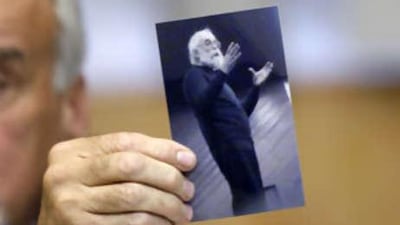 The Serbian chief war crime prosecutor Vladimir Vukcevic shows a picture of Radovan Karadzic during a news conference in Belgrade today. Mr Karadzic was arrested on Monday near Belgrade posing as a doctor of alternative medicine, sporting long hair, a beard and glasses to hide his face.