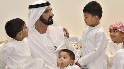 Sheikh Mohammed listens to a young boy at the inauguration of the Family Village.