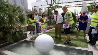Judge Kamelia Zaal, left, Creative landscape director of Al Barari, and Jo Thompson, third left, director of Jo Thompson Garden Design, along with other judges look at the Pearl Garden display. Ravindranath K / The National