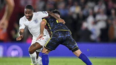 Raheem Sterling of England is tackled by Besar Halimi of Kosovo.