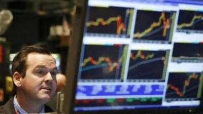 A trader on the floor of the New York Stock Exchange anxiously watches his screen.