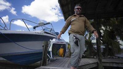 Bryan Stern, founder of Project Dynamo, carries a bird being rescued from a sanctuary in Pine Island. AP