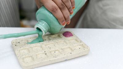 Paint being poured into a tray.