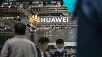 Visitors walk past a logo at the Huawei booth at the Auto Shanghai 2021 show in Shanghai. The company has an 8 per cent market share in the smartphone manufacturing segment, according to Counterpoint Research. Bloomberg
