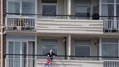 A Southport resident waves a Union Jack flag. PA