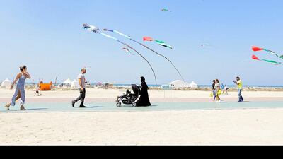 People are seen walking along Kite Beach in Dubai. Jeffrey E Biteng / The National