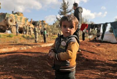 A displaced child looks to the camera near the town of Batabu. Many children froze to death as they sought shelter near the closed Turkish border in flimsy tents. AFP