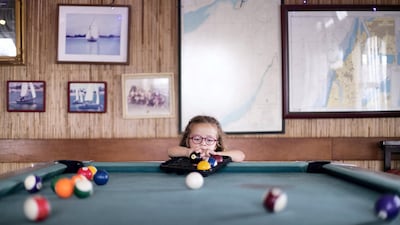 Ella-May Elba-Pawsey, 4, arranges the billiard balls at the club. Reem Mohammed / The National