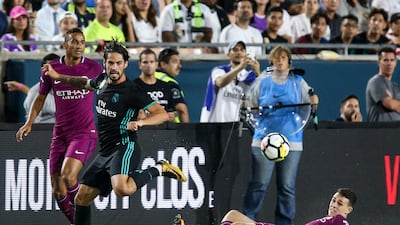 Manchester City midfielder Phil Foden, right eyes the ball with Isco of Real Madrid. Ringo Chiu / AFP