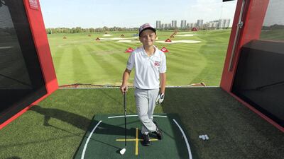 Oscar Murphy, the winner of a skills challenge from the HSBC Future Falcons golf programme, got to play a shot on the 15th hole against his hero Rory McIlroy on the opening day of the Abu Dhabi HSBC Championship. Chris Whiteoak / The National