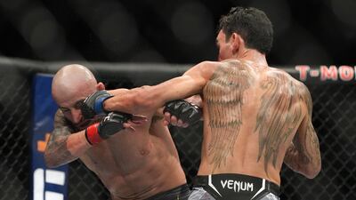Max Holloway lands a punch on Alexander Volkanovski during their bout at during UFC 276. Reuters