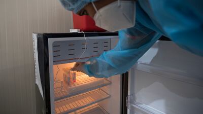 A health worker freezes a swab collected at the testing centre located in the car park of Dubai's main immigration office.