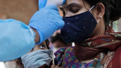 A child looks at his mother being screened for Covid-19 symptoms at an apartment complex in Mumbai, India. AP
