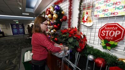 Volunteer Nicole Schreiner places a display of poinsettias in the Norad Tracks Santa centre at Peterson Air Force Base. AP