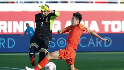 Kyrgyzstan's goalkeeper Matiash clears the ball under pressure from Wu Lei. AP Photo