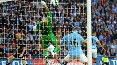 Ben Watson, left, watches his header loop over Joe Hart, centre, to give Wigan Athletic victory in the FA Cup final.
