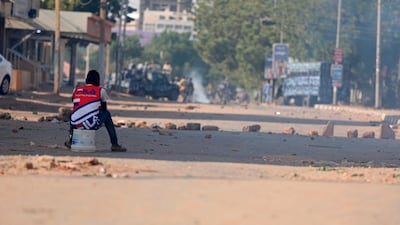A protester sits in a street facing security forces at a demonstration, in Khartoum. Protesters have taken to the streets in the capital and across the country over dire living conditions. AP