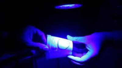 An ultraviolet light is used to illuminate fingerprints at Forensic Science Department in Abu Dhabi.