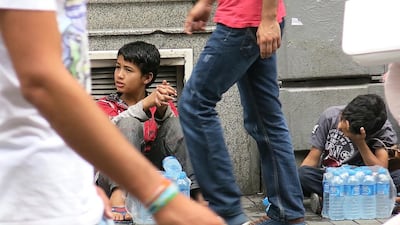 Dom Gypsy boys take a break from selling water on Istanbul’s Taksim Square. Many Dom children, refugees of Syria’s war, beg but those who can, sell water instead. Dan Boylan for The National / September 22, 2014