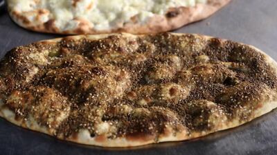 Freshly baked flatbread garnished with thyme and cheese ready to be served at Abu Shadi's bakery. The baker says many of his customers of three decades can no longer afford to buy his modest manousheh becuase of skyrocketing prices caused by inflation. AFP