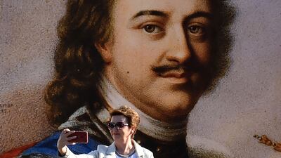 A woman takes a selfie in front of a poster of Peter the Great in St Petersburg, on the 350th anniversary of the tsar's birth. AFP