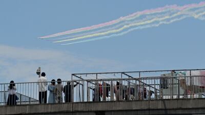People watch a performance by Blue Impulse.