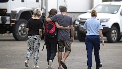 Family walks with a police officer, New Zealand. Getty Images