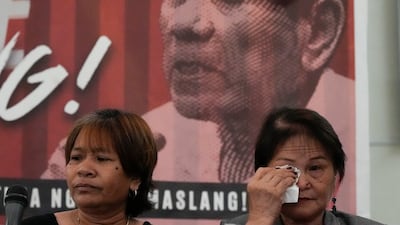 The relative of a victim of former Philippine president Rodrigo Duterte's 'war on drugs' wipes away tears after his arrest, in Quezon City. AP