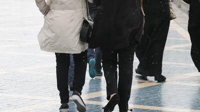 Women walk along the Abu Dhabi corniche. Forecasters have issued a warning due to strong winds expected across the emirates. Philip Cheung for The National