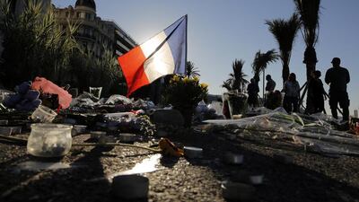 On the famed Boulevard des Anglais in Nice, southern France, on July 17, 2016, a French flag stands tall amongst a floral tribute for the victims killed during a deadly attack when a man drove a truck through crowds celebrating Bastille Day, killig at least 84 people including children. Laurent Cipriani/AP Photo