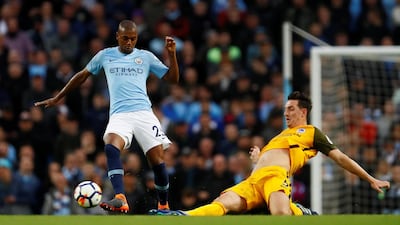 Manchester City's Fernandinho is challenged by Lewis Dunk of Brighton. Reuters