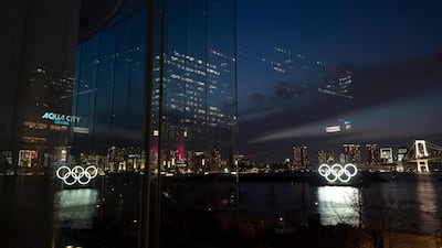 The Olympic rings are reflected in the glass wall of a wedding chapel in the Odaiba section of Tokyo. AP
