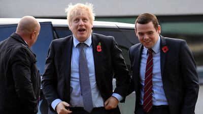 Britain's Prime Minister Boris Johnson (C) is greeted by Conservative party candidate for Moray, Douglas Ross (R) as he arrives for a general election campaign visit to Diageo's Roseisle Distillery near Elgin, north east Scotland AFP