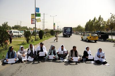 Afghans hold placards written in Farsi saying “Rescue Ghazni Province” as they block a busy Kabul road to pressure government to secure Ghazni province. EPA