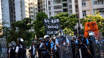 Police erecting black flag that says "Warning, Tear Smoke" and orange flag that says "Disperse, Or We Fire" as protesters on the other side built roadblocks and continued to push towards the police. Xun Yuan for The National