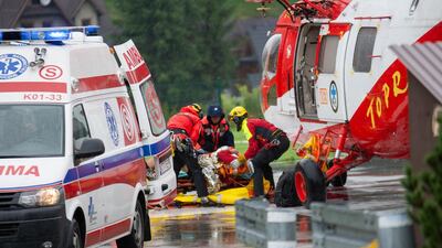 Polish rescue workers move an injured tourist into a helicopter near Zakopane, Poland after a sudden lightning storm killed five people, including two children. AFP / Piotr KORCZAK